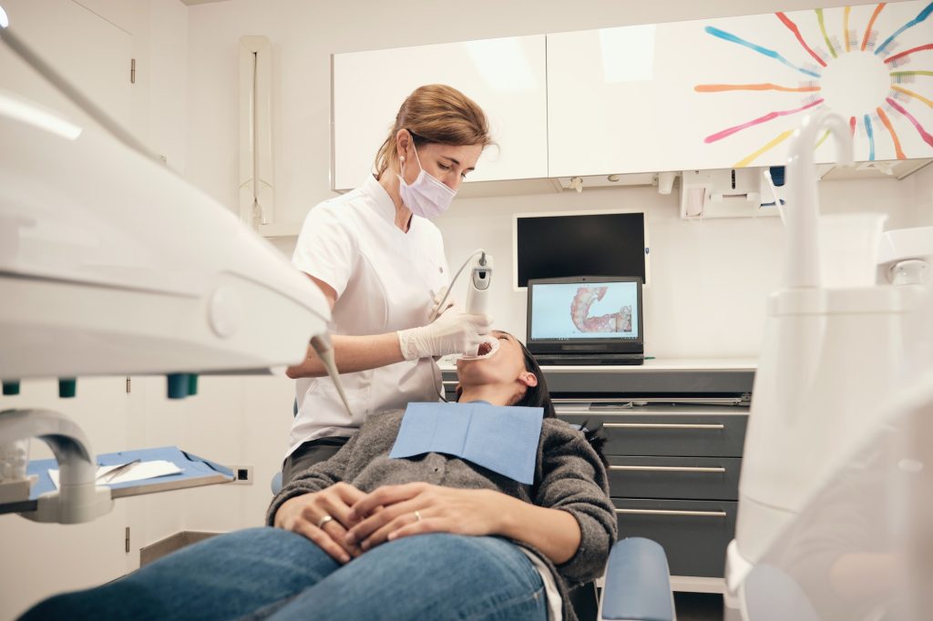 female dentist scanning teeth of woman 2 1024x682.jpg